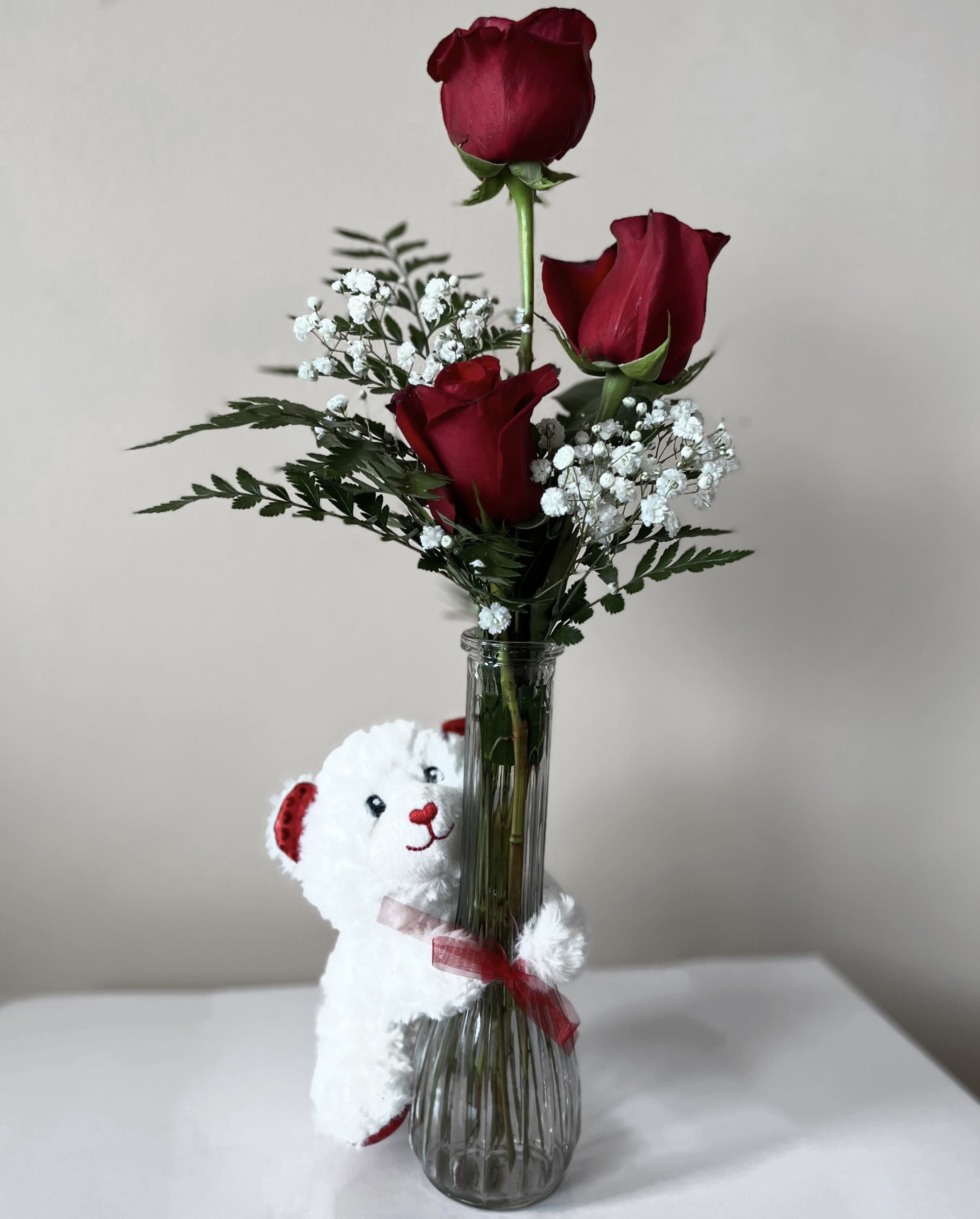 3 Red Roses and a bear - Embrace your feelings with a classic gift of long-stem red roses. Displayed elegantly in a glass vase and artistically designed by our select florists, these stunning roses send a memorable message to your special someone that help you express yourself perfectly, no matter what the occasion. Fresh long-stem red roses, artistically arranged by our florists with fresh gypsophila and a Cute Plush Bear