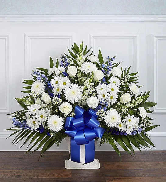 White daisies and roses in a blue ribboned vase arrangement