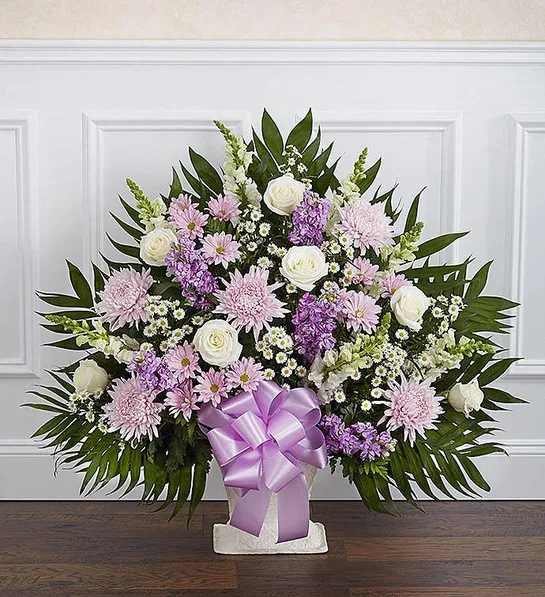 Standing floral spray with pink and white flowers and a lavender ribbon