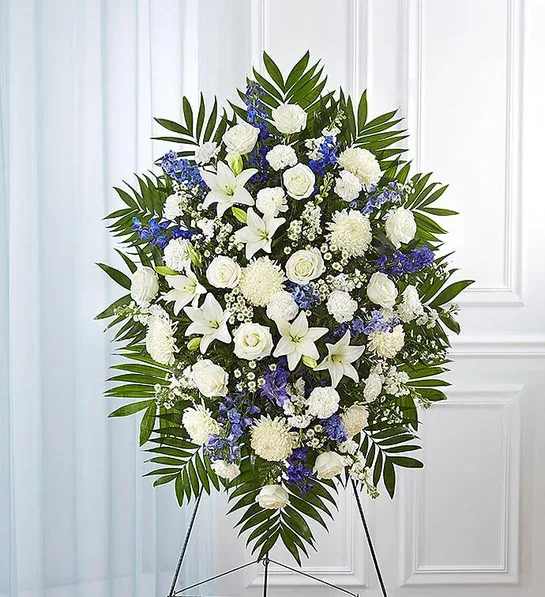 Standing floral spray of white and blue flowers on an easel