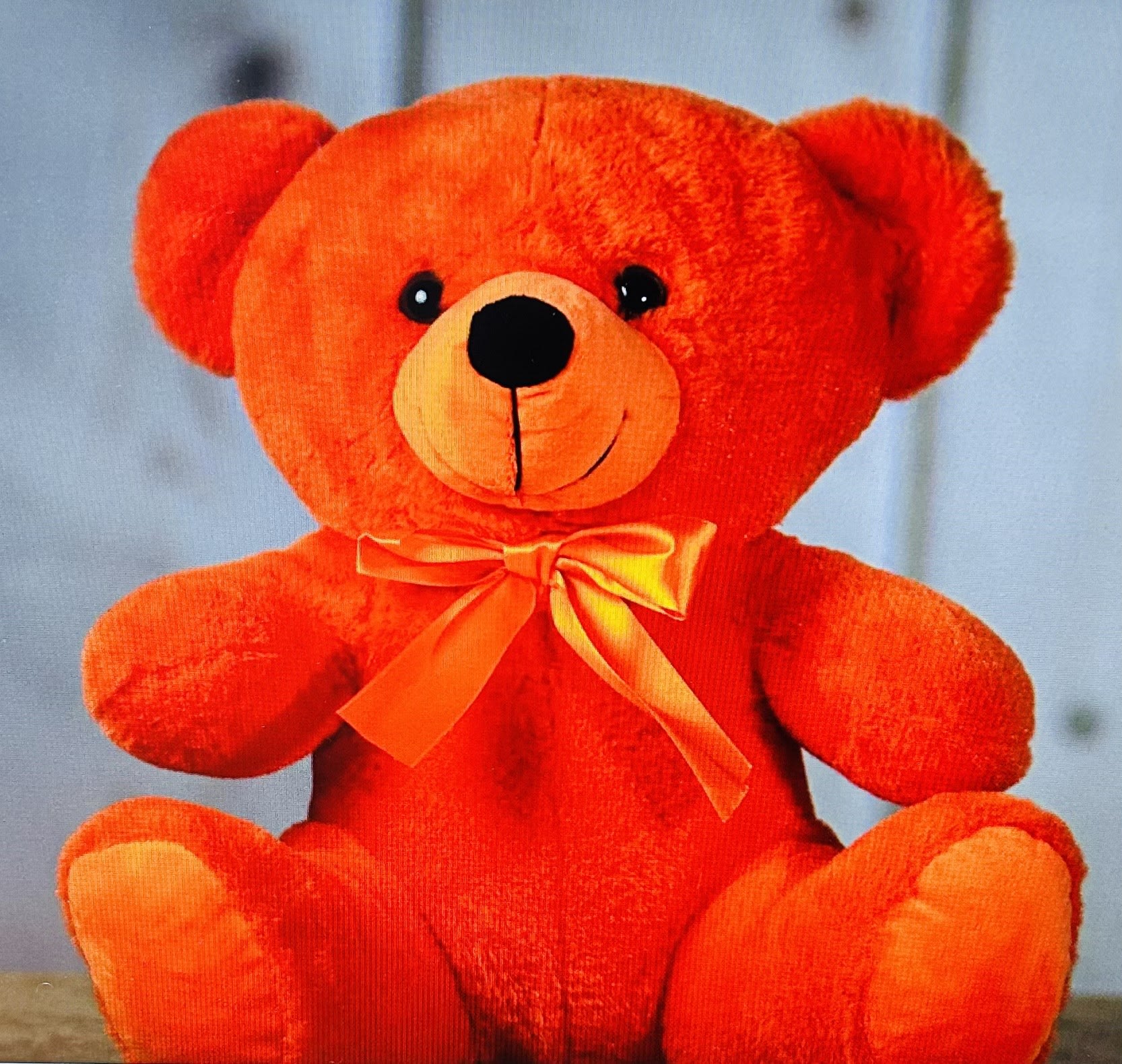 Orange teddy bear with a ribbon bow