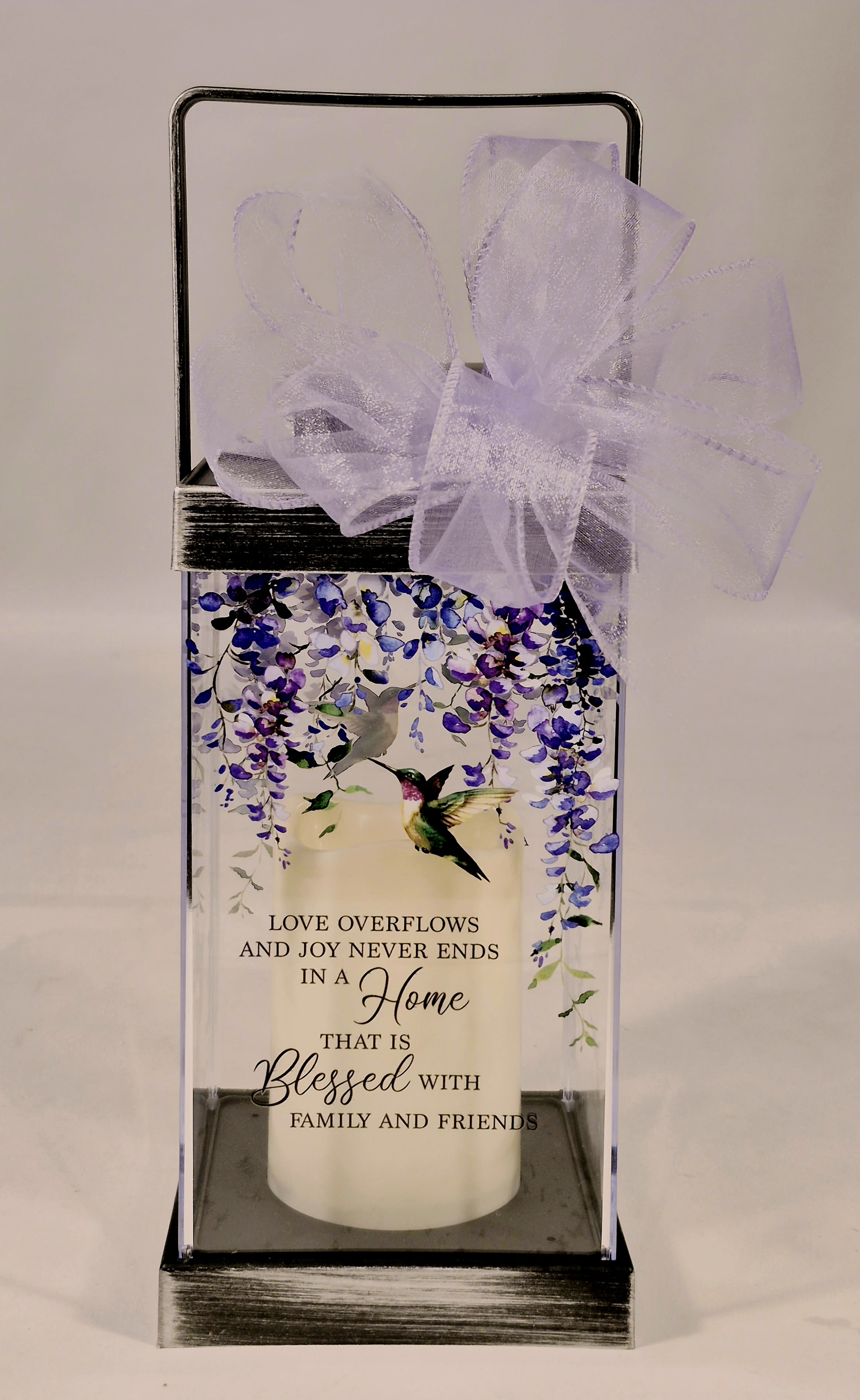 Love Overflows Blessed Lighted Lantern - Blessed lantern is a beautiful flameless LED Candle Lantern made with high-quality polyresin finish with a built in automatic timer. Comes adorned with a lavender bow. Wonderful gift for housewarming, birthday or just because. 6 hours ON/18 Off (3 AAA batteries included)  W: 4.75" H: 13" D: 7.75"