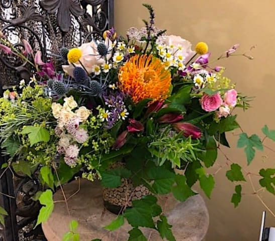 Mixed bouquet with orange, pink, purple, and white flowers in a vase