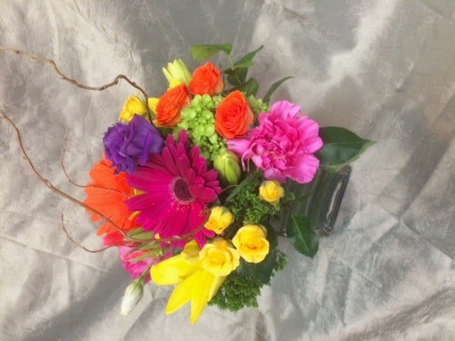 Bright mixed bouquet with gerbera daisies, roses, and carnations in a vase