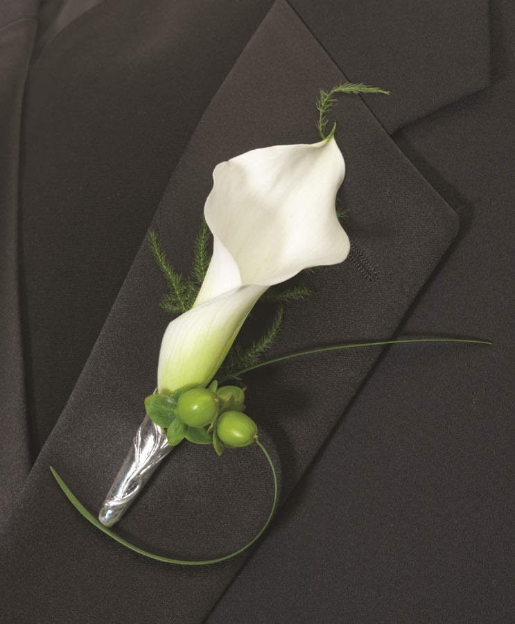 White calla lily boutonniere with green berries on a black suit jacket
