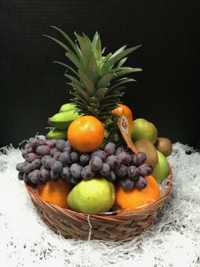 Fruit basket with pineapple, grapes, oranges, bananas, and pears