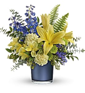 Yellow lilies and blue flowers in a blue vase