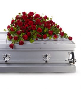 Red rose spray on a silver casket