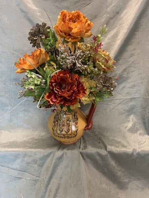 Orange floral arrangement in a decorative ceramic vase