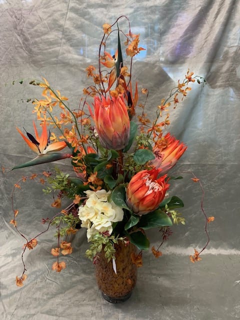 Orange tropical flowers arranged in a glass vase