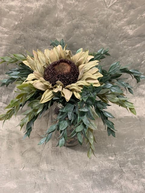 Sunflower arrangement in a vase with cascading greenery