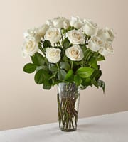 White roses arranged in a clear glass vase
