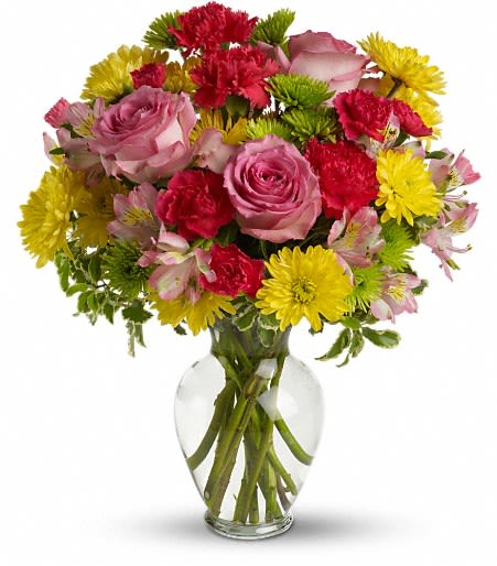 Mixed bouquet of pink roses, red carnations, and yellow daisies in a clear glass vase