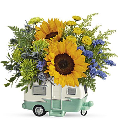 Sunflowers and mixed blooms arranged in a small camper-shaped container
