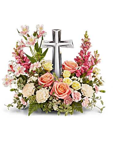 Pink and white floral arrangement with a silver cross centerpiece