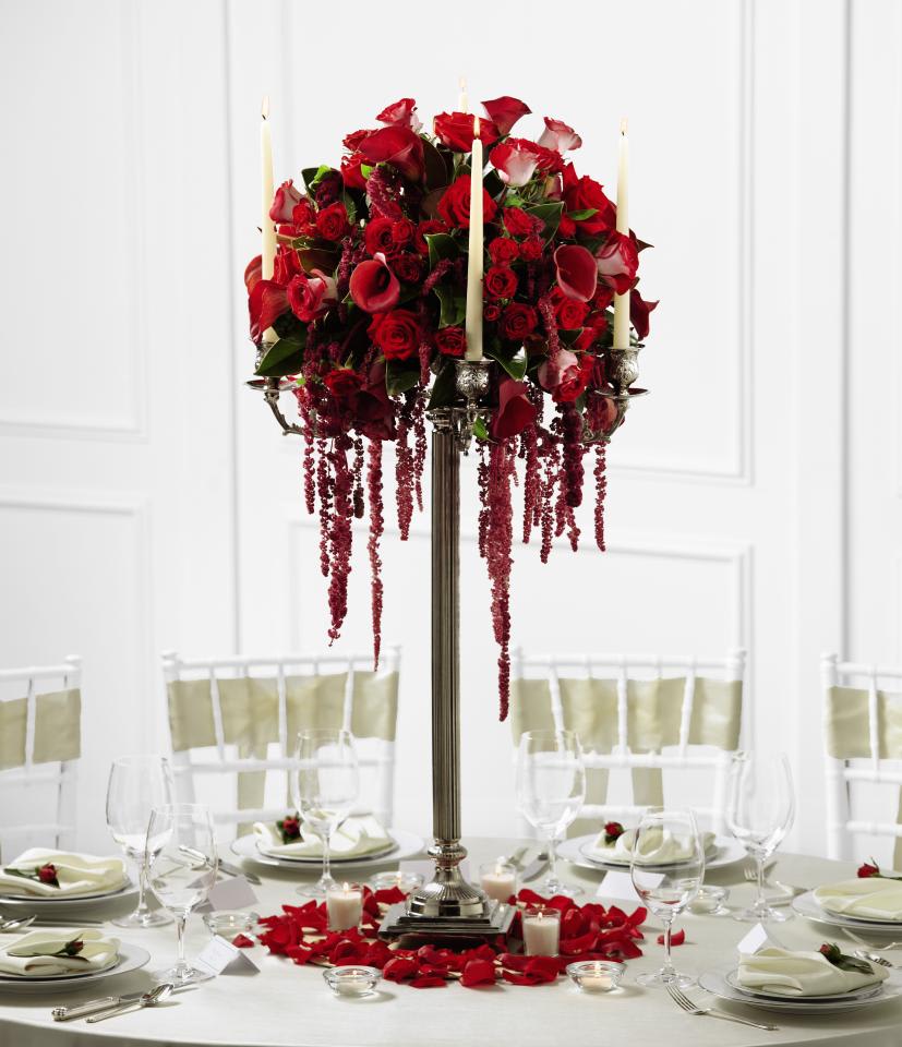 FTD Regency Centerpiece - The FTDÂ® Regencyâ¢ Centerpiece is a fantastic display of blooming  elegance to give your wedding guests an impression that will last a  lifetime. Red roses, spray roses, mini calla lilies, hanging amaranthus  and bi-colored red and white roses are arranged to perfection and  situated within a silver candelabra holding four white taper candles. At  the base of this arrangement are additional votive candles and  scattered rose petals to create a high impact look of sweet  sophistication. Approx. 43âH x 20âW.  