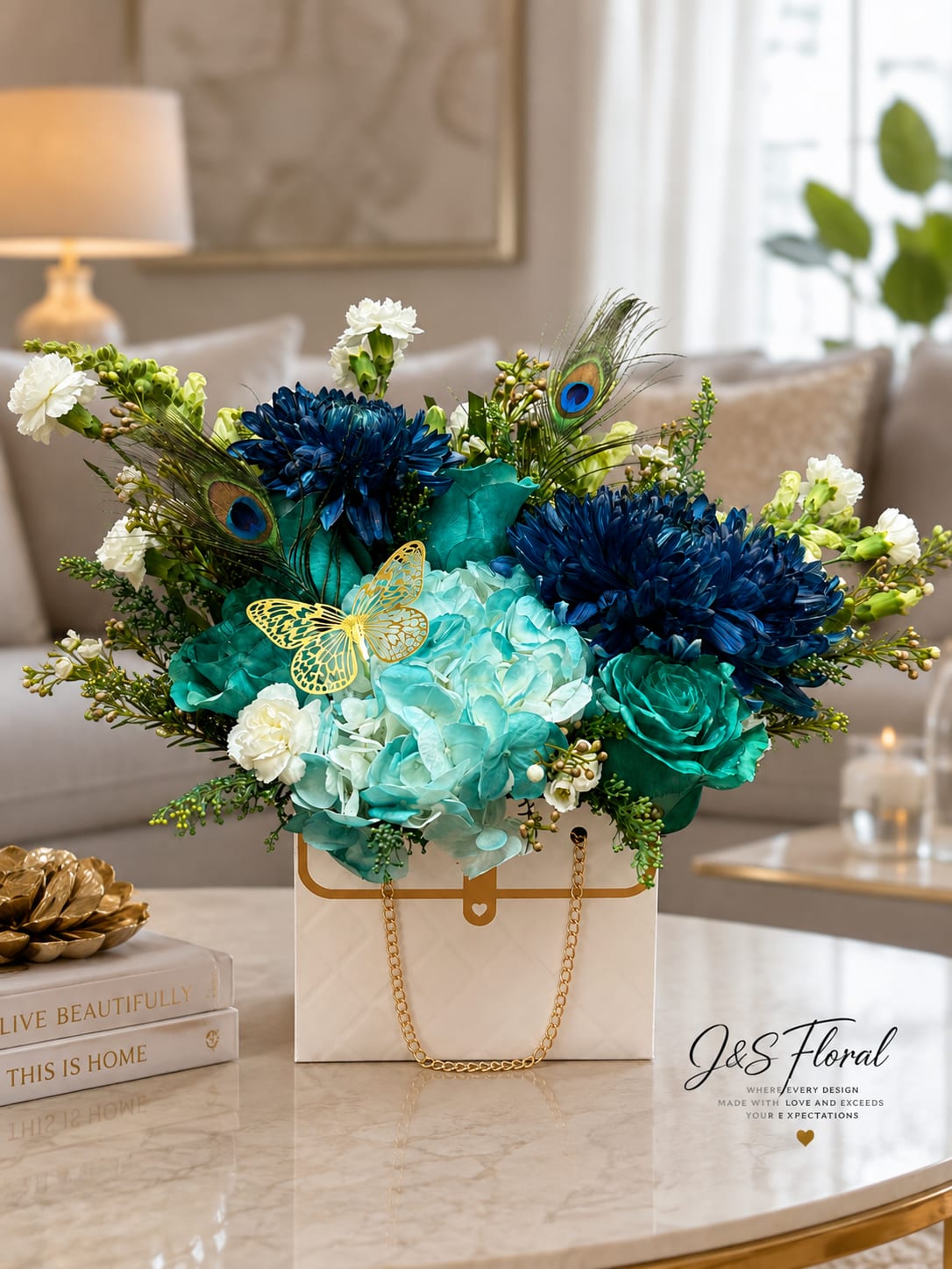 Blue and teal floral arrangement in a white gift box with gold chain handles