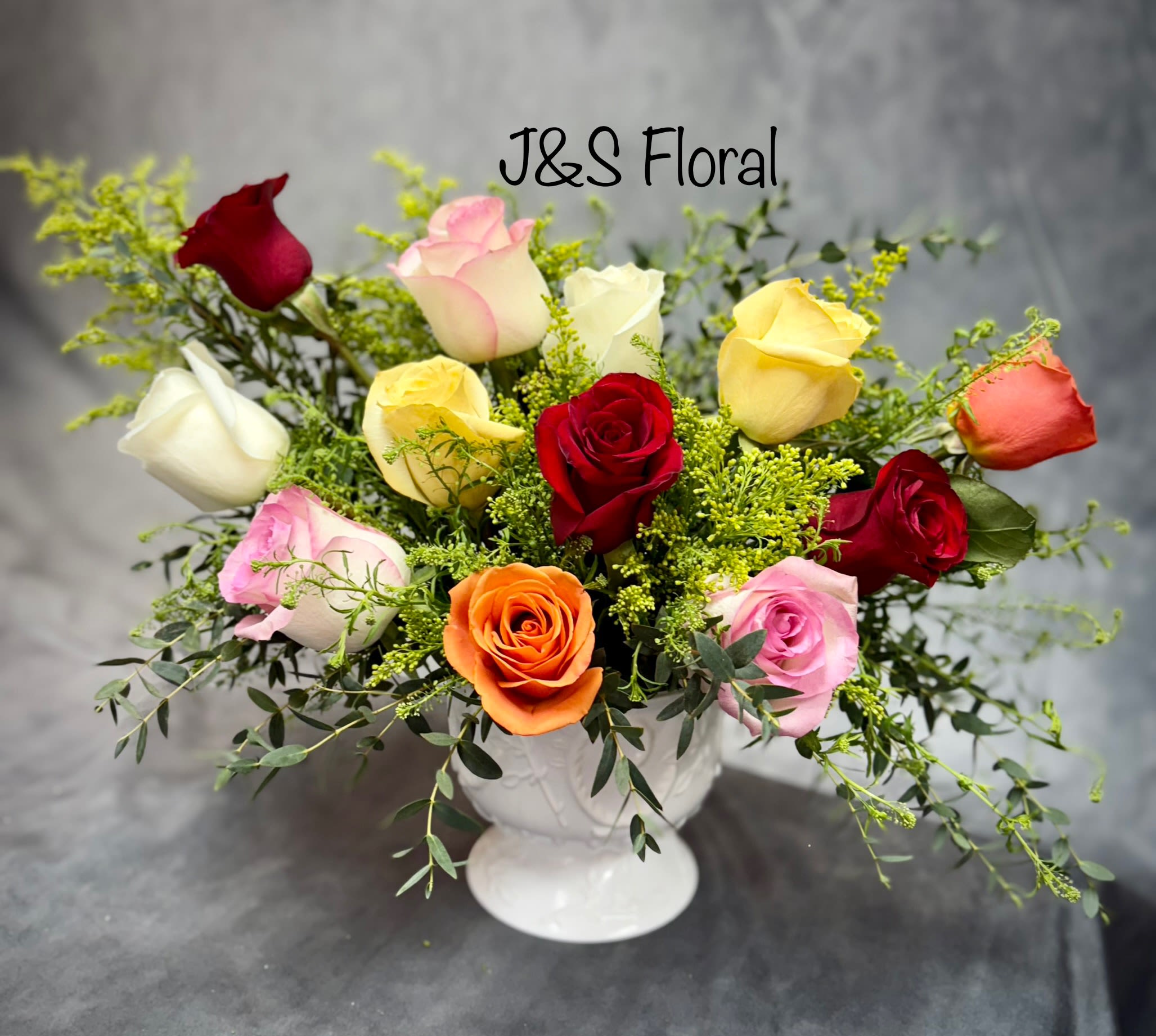 Mixed roses in a white pedestal vase