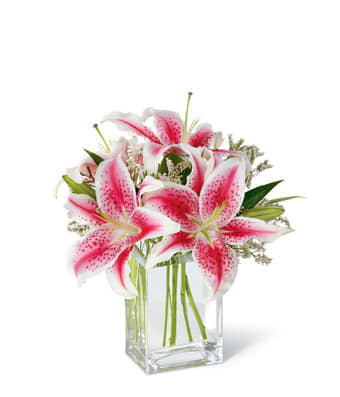 Pink and white lilies in a clear glass vase