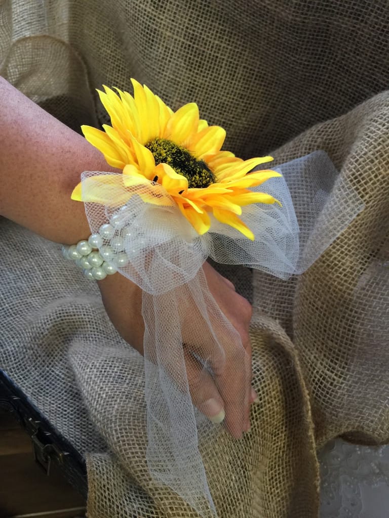 Yellow sunflower wrist corsage with white tulle and pearl bracelet