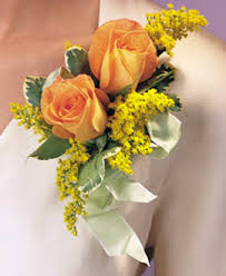 Small orange rose boutonniere with yellow filler flowers and ribbon