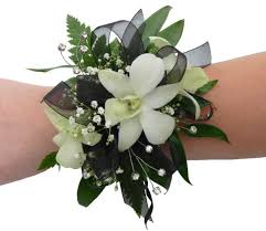 White floral wrist corsage with ribbon and greenery