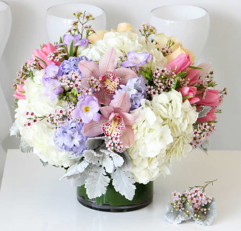 Mixed pastel bouquet in a glass vase with a matching boutonniere
