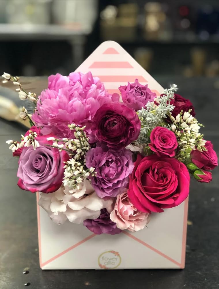 Pink and purple rose bouquet in a white gift box