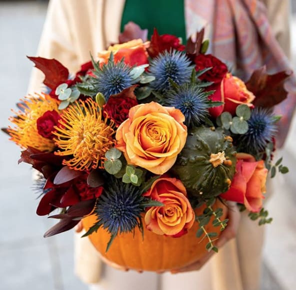 Pumpkin Please! - A fresh pumpkin filled with vibrant fall blooms!