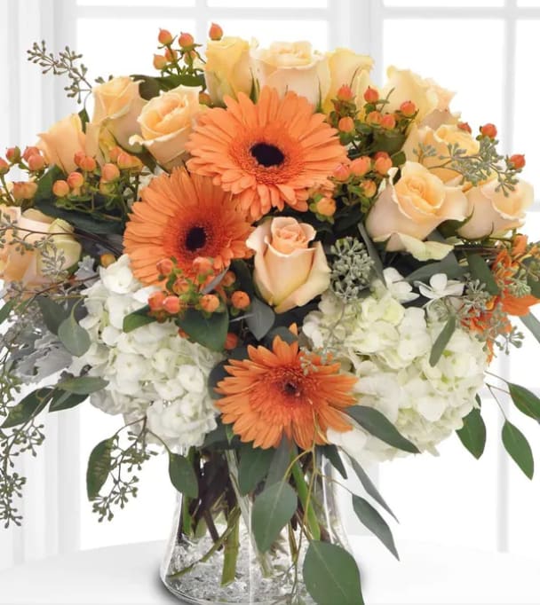 Autumn Smiles - Absolutely exquisite! This bouquet is a fall flower fantasy come true. All the first hues of this   autumn are  captured in a stylish glass vase. So pretty, you might have to order one for a friend and one for yourself!  Approximately 17" W x 20" H  Orientation: One-Sided