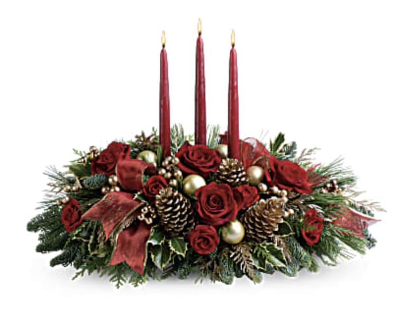 Classic Christmas Centerpiece - This luminous centerpiece is a glowing way to spread the joy of the season. Whether displayed on the dining table or placed elsewhere, it will light up any room with holiday cheer.  Gorgeous gold balls, radiant red roses, spray roses and pretty winter greens are arranged around an elegant white pillar candle. It's regal and radiant.  Approximately 26" W x 14" H   