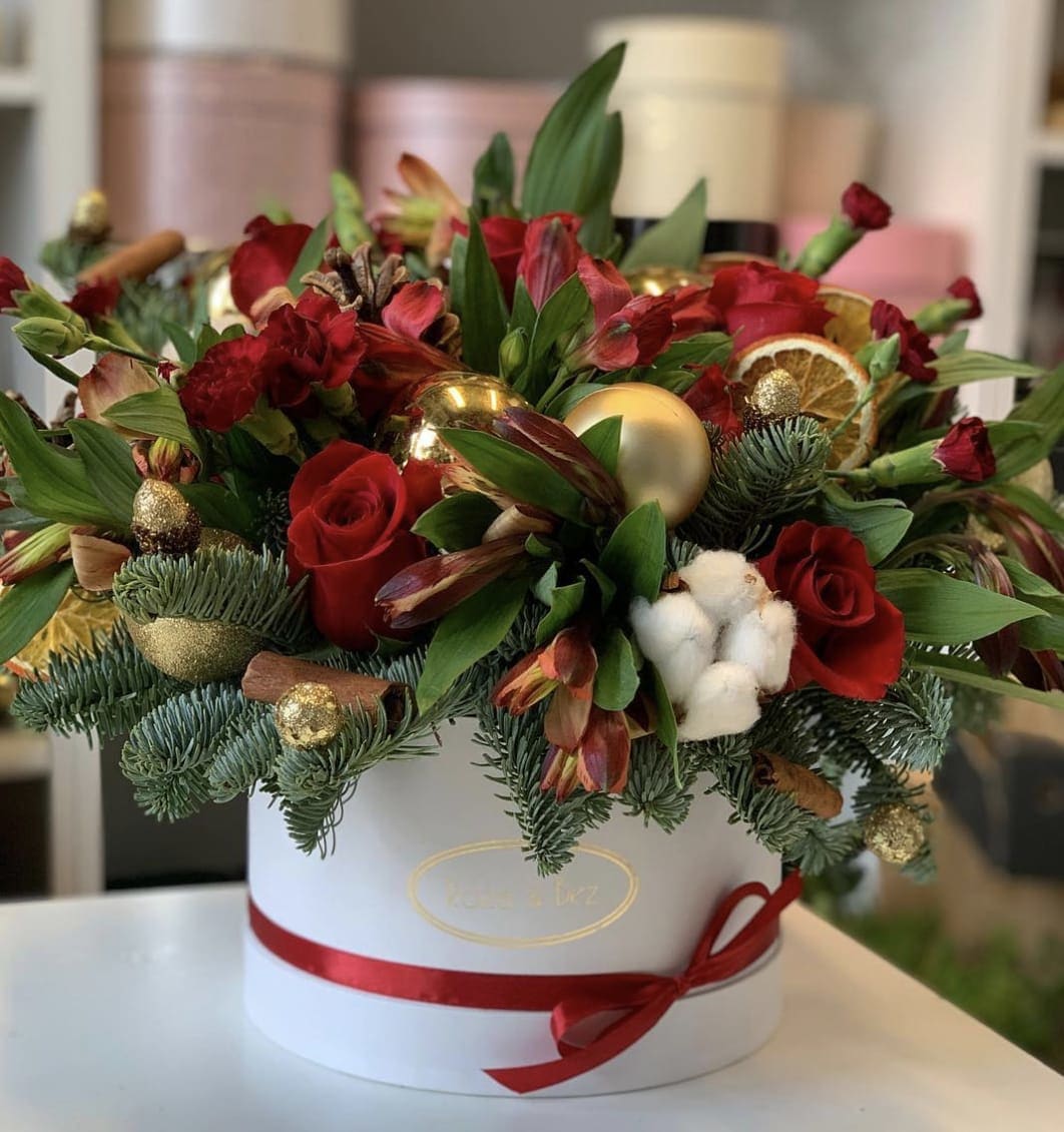 Red roses and mixed flowers in a white hat box with gold ornaments