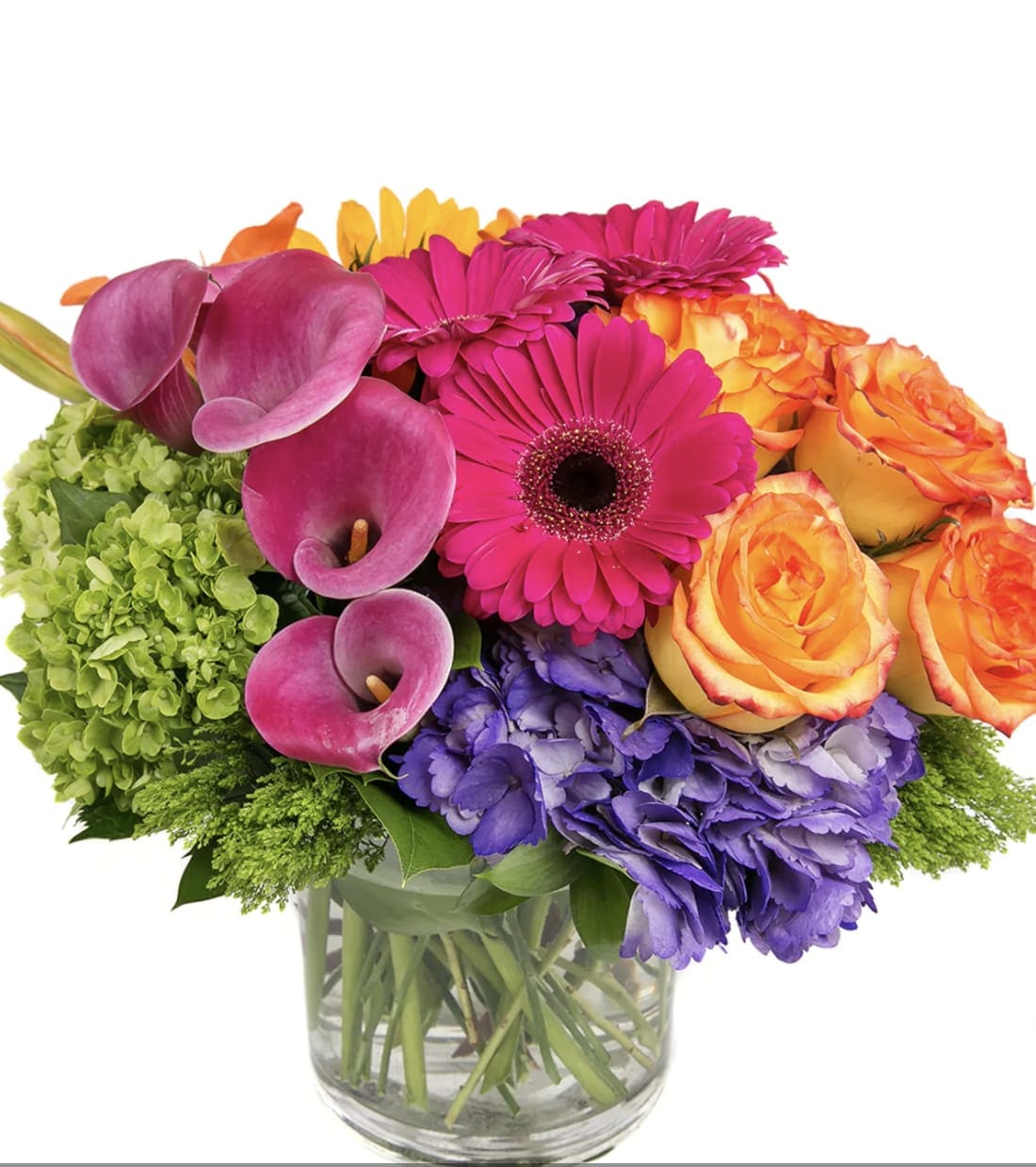 Colorful bouquet with roses, gerbera daisies, calla lilies, and hydrangeas in a glass vase