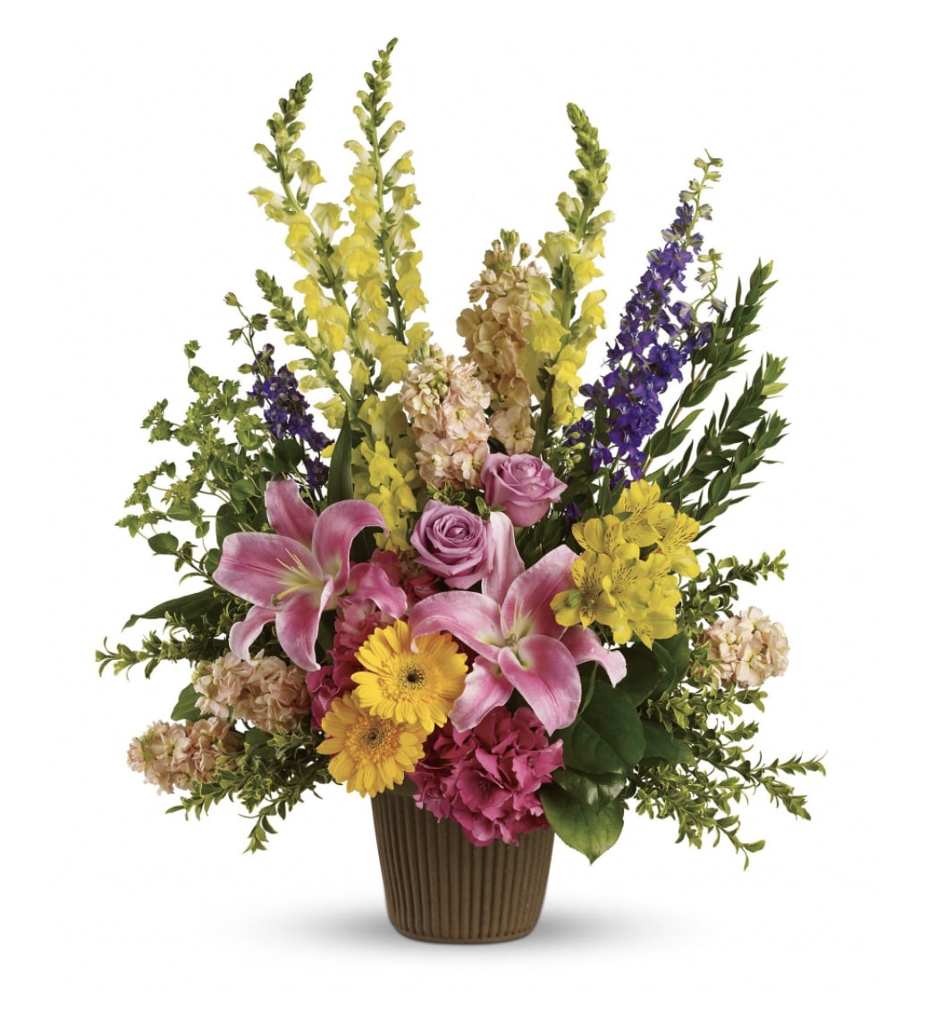 Mixed bouquet of lilies, roses, and daisies in a brown vase