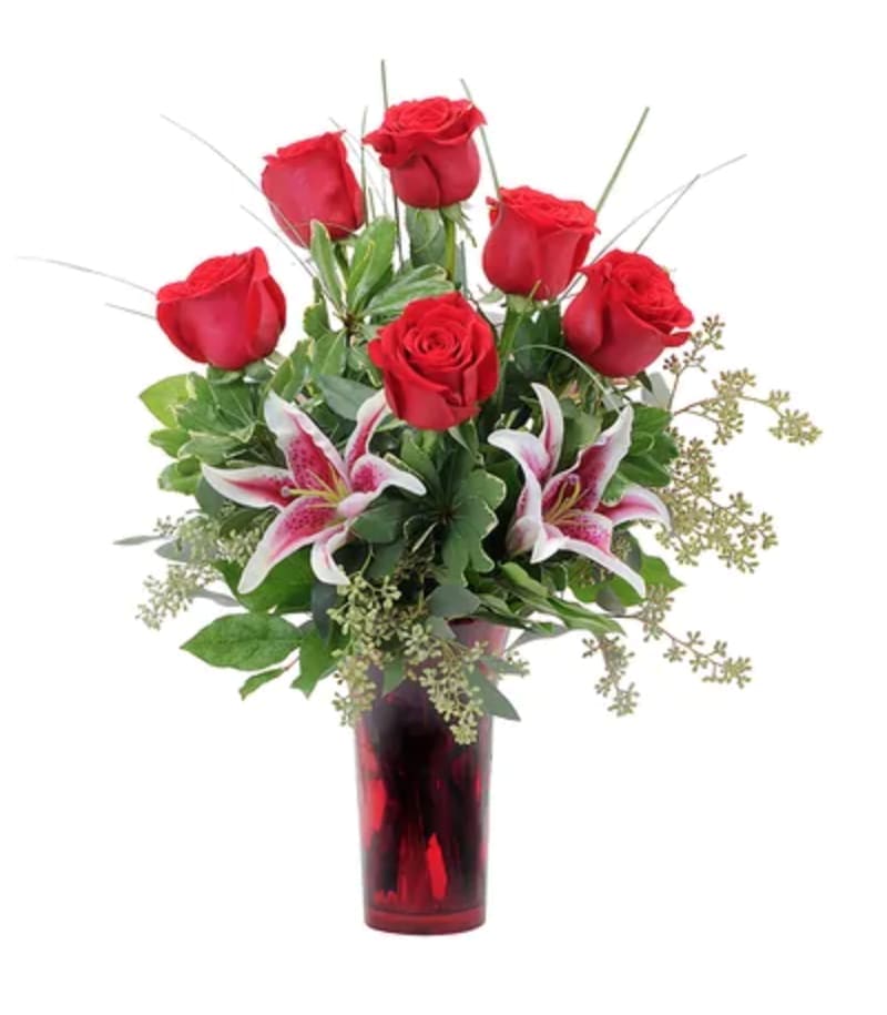 Red roses and pink lilies in a red glass vase