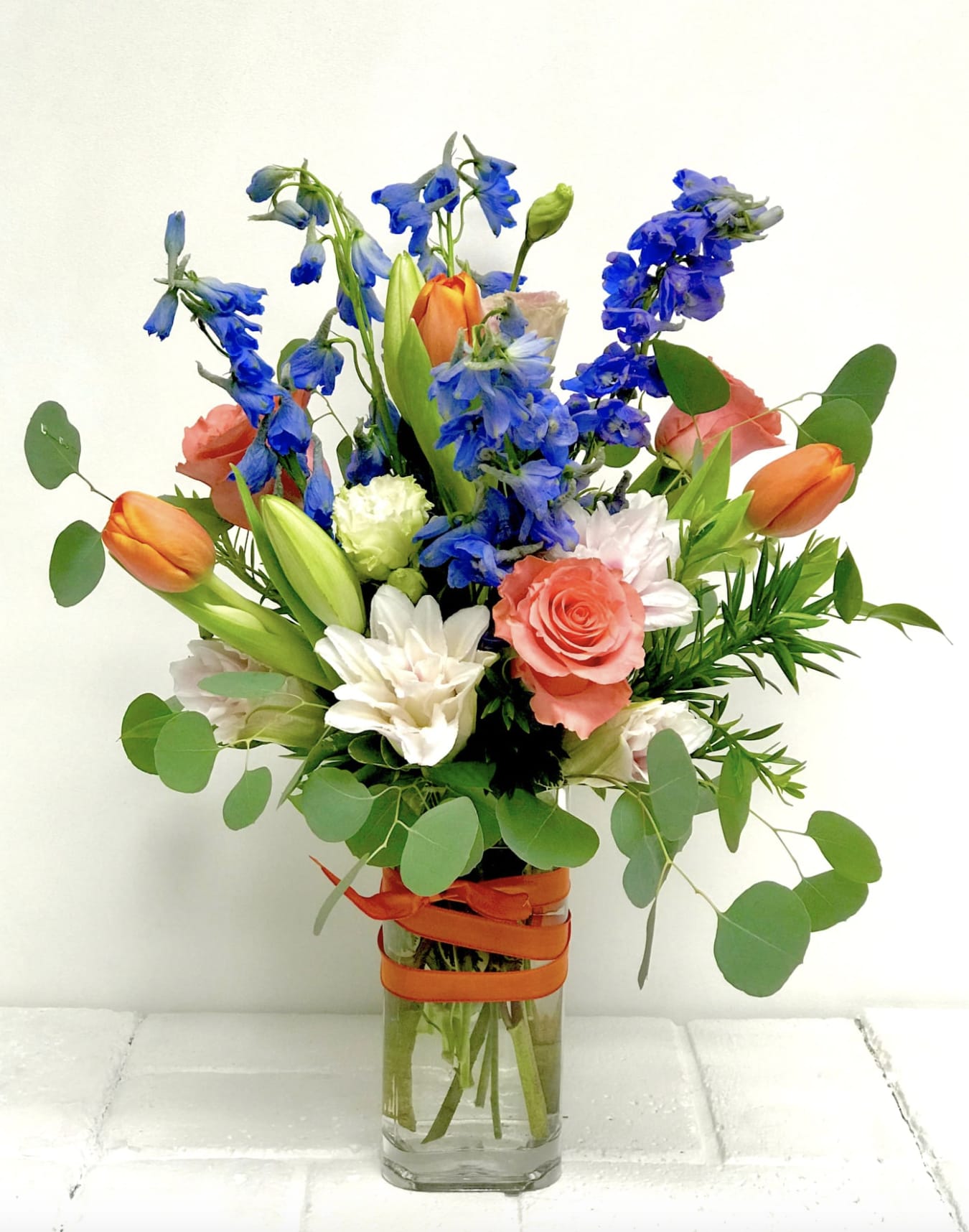 CSUF Dreams - Paint the town with joy! Send a hot orange and cool blue bouquet of roses, delphinium and tulips (when in season).  This bouquet can also be made as a wrap or a bit smaller. Call us for more options