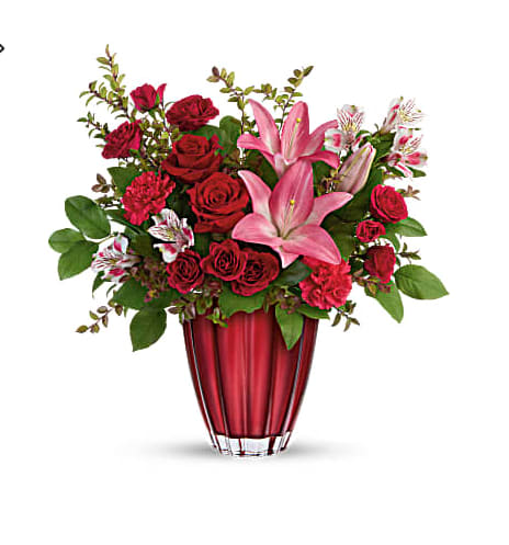 Red roses and pink lilies arranged in a red vase
