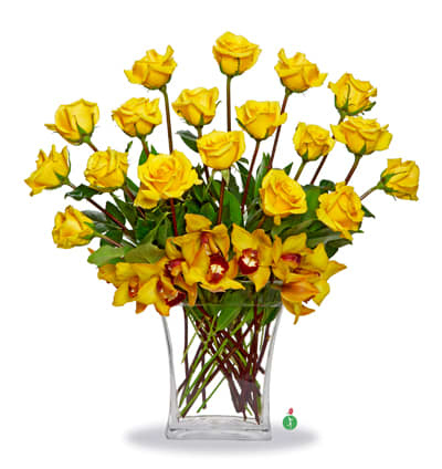 Yellow roses and yellow orchids arranged in a clear glass vase