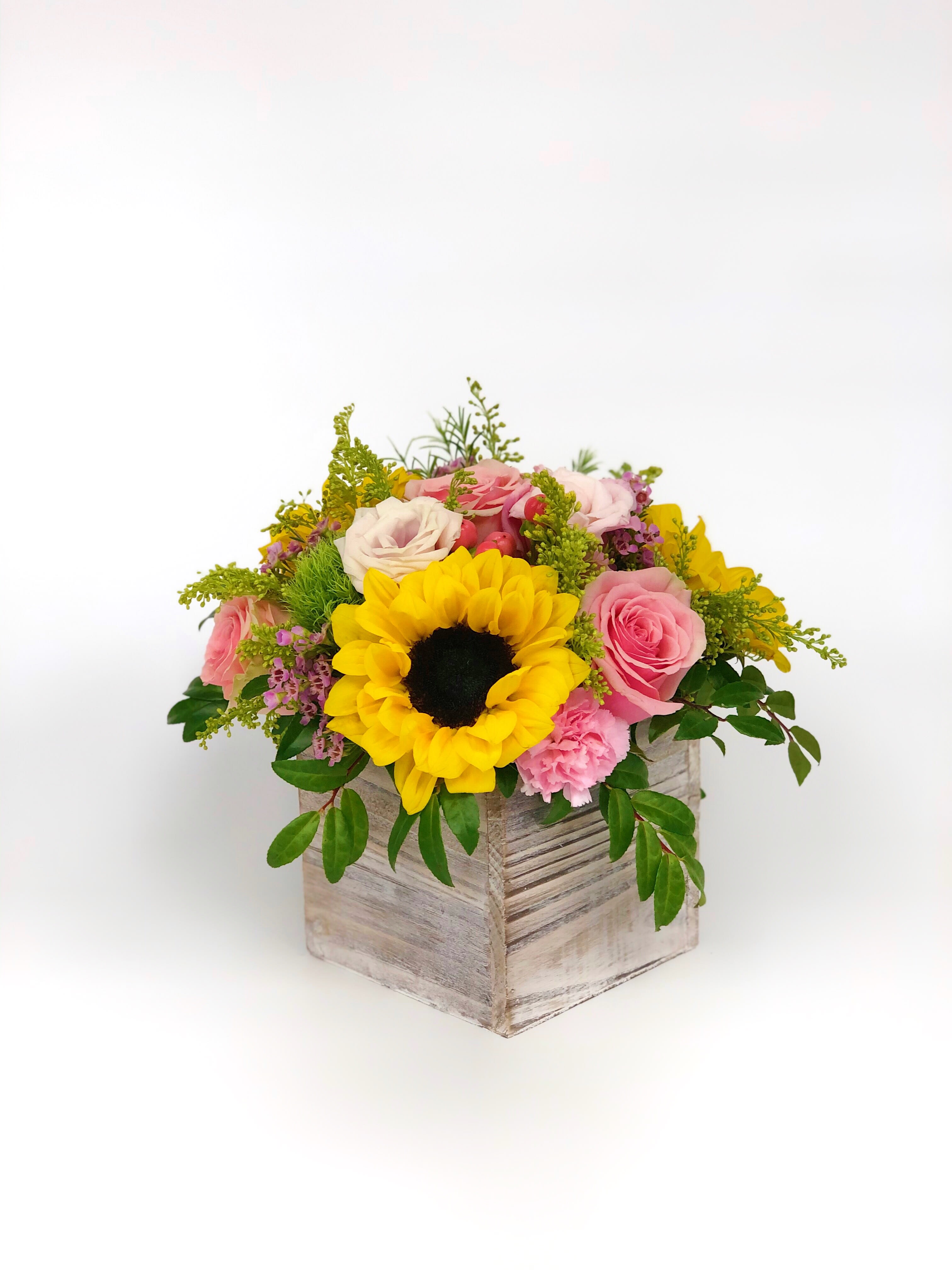 Sunflower and pink rose arrangement in a rustic wooden box