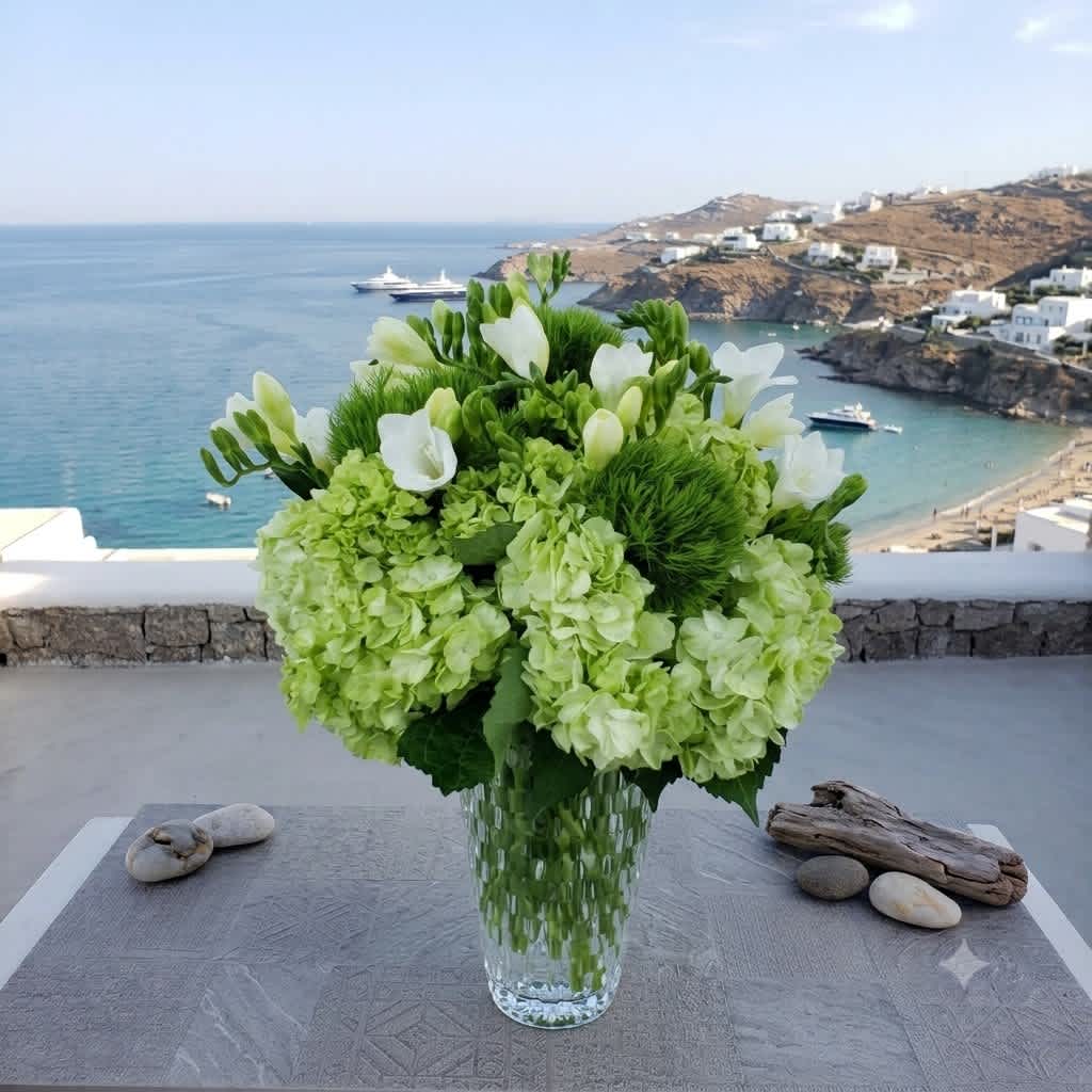Green and white floral arrangement in a clear glass vase