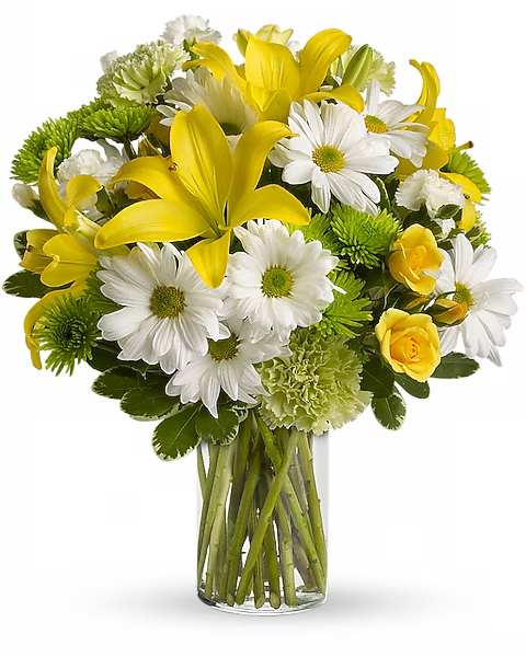 Yellow lilies and white daisies in a clear glass vase