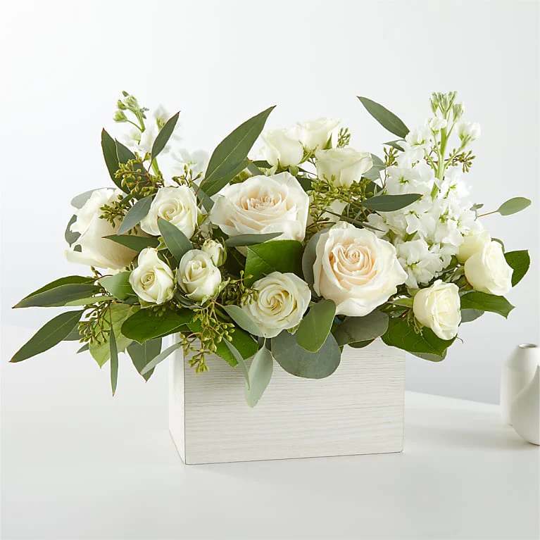 White roses and white blooms arranged in a white box