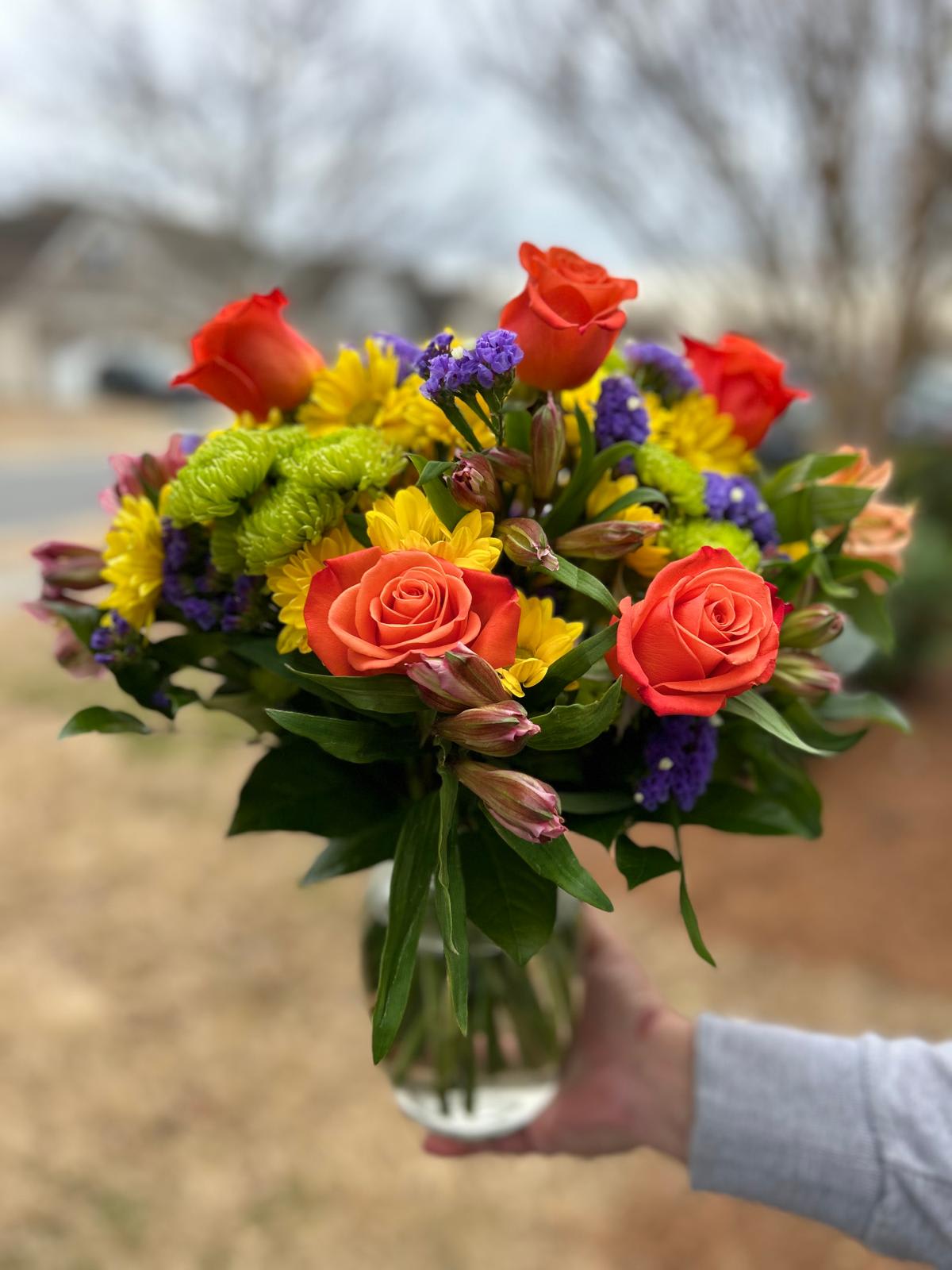 June Bouquet - Flowers of yellow and green, and pops of orange and purple. Full of color and texture.  Crystal Clear Glass Vessel  Place your Order Online Monday to Saturday before 1:00 p.m. (E.T.) for same-day delivery. “Orders received after hours will be delivered the next business day”. Check our coverage area. Occasionally, flowers and/or container substitutions happen due to weather, seasonality, and market conditions, which may affect availability. If this is the case with the gift you’ve selected, we will ensure that your arrangement's style, theme, and color scheme are preserved and will only substitute items of equal value or higher value.  CARE INSTRUCTIONS Keep the flower arrangement hydrated with natural water and change the water every two days. Do not spray any cleaning product on the flower arrangement. Do not place heavy objects directly on the flower arrangement. Keep flower arrangements out of direct sunlight and extreme heat.