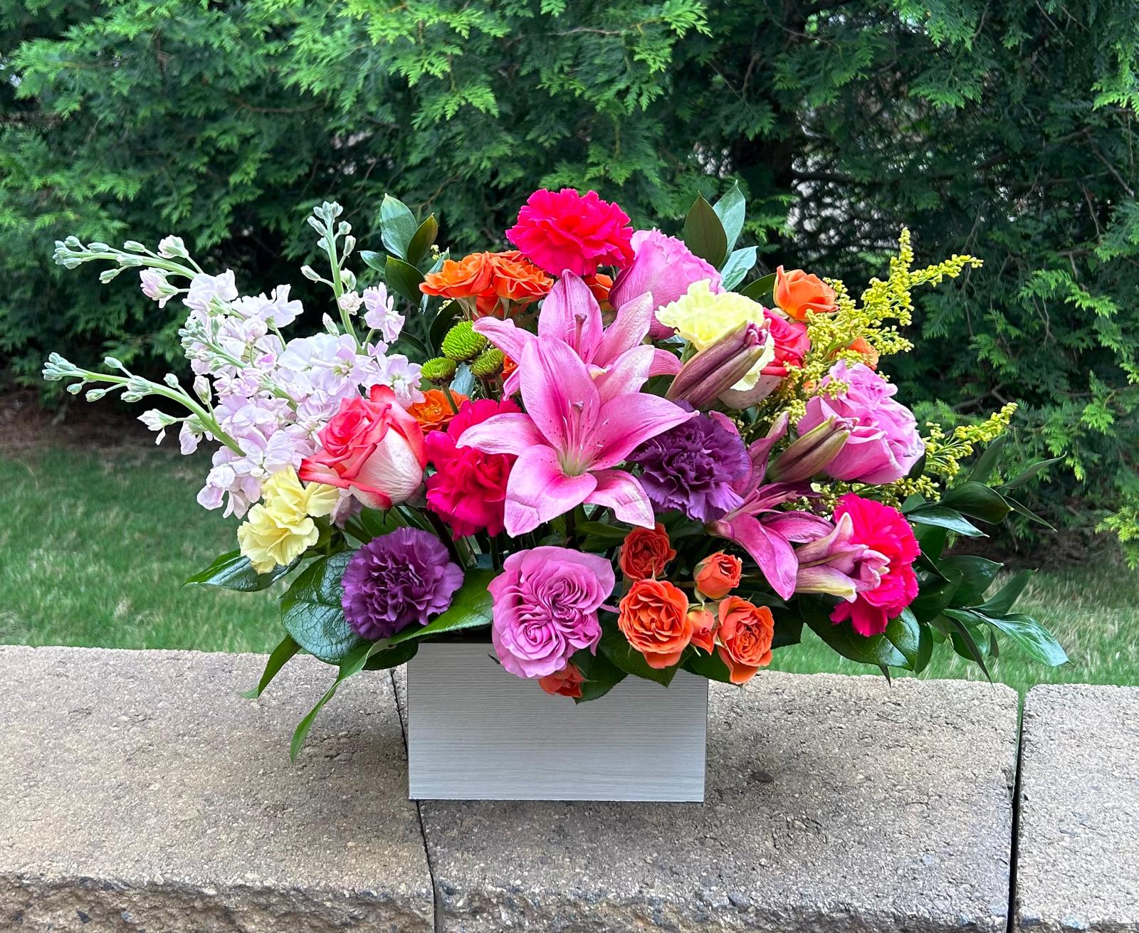 Colorful mixed flower arrangement in a white rectangular box