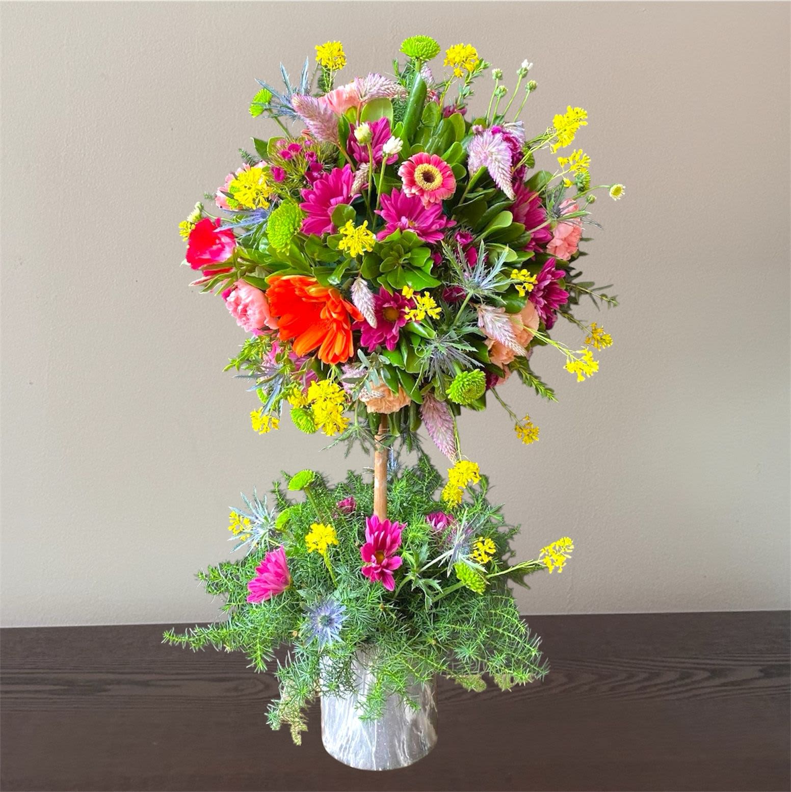 Topiary Savannah - "PLACE YOUR ORDER AT LEAST 2 DAYS PRIOR TO THE DELIVERY DATE”  These flower trees will make anyone fall in love. Each one is unique. All Occasions. Size: 6" in diameter of the topiary. Ceramic Pot. Check our coverage area.  Occasionally, flowers and/or container substitutions occur due to weather, seasonality, and market conditions, which may affect availability. If this is the case with the gift you’ve selected, we will ensure that the style, theme, and color scheme of your arrangement are preserved and will only substitute items of equal value or higher value