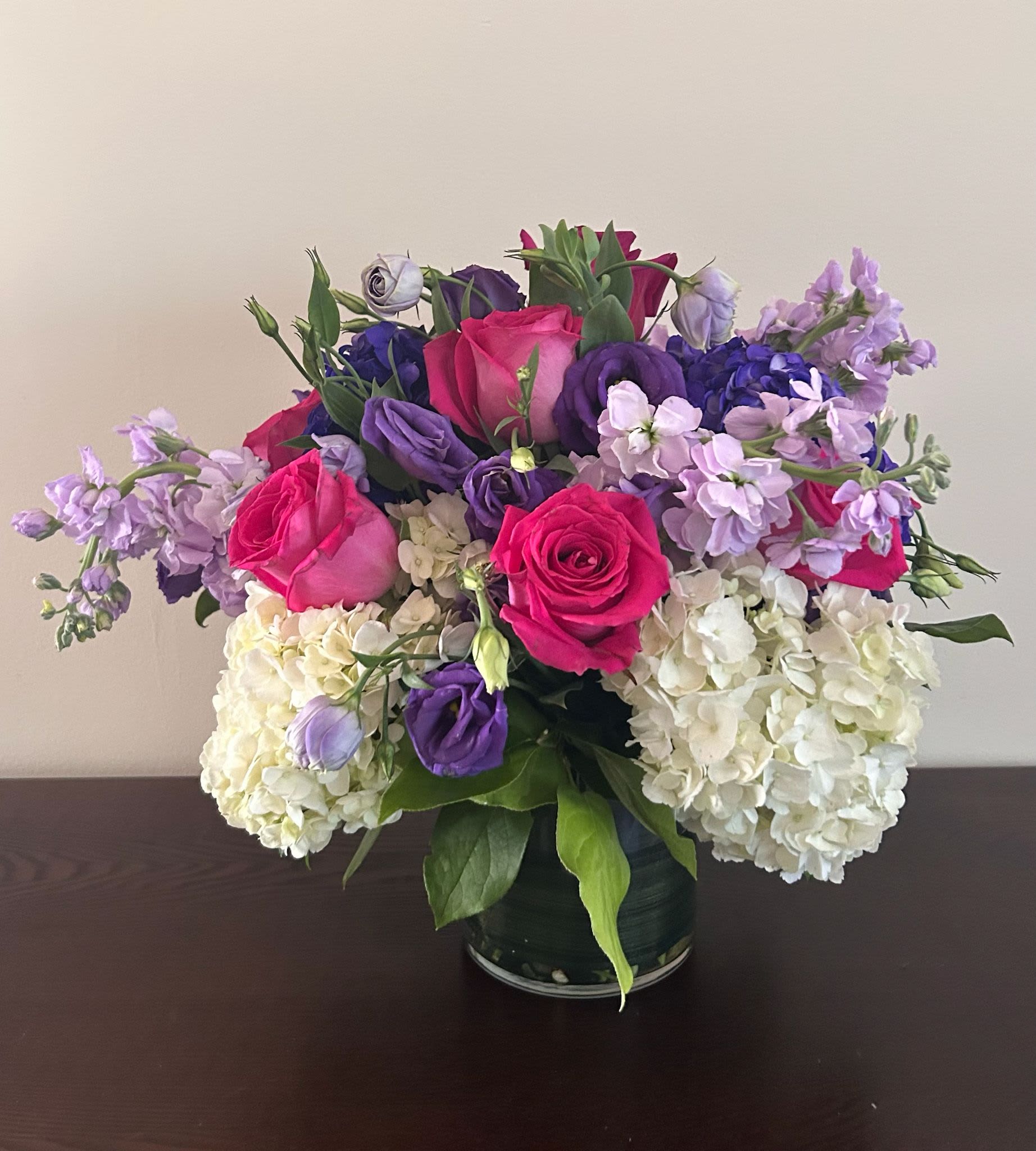  Evelyn  - Real flowers, real luxury. Whether it's for a birthday, a thank you, or just because, this fresh floral arrangement is designed to impress and delight. Bloom Details: Stock, Lisianthus,  Roses, Green Foliage Mix.  Presented: Crystal Clear Glass Vessel  Place your Order Online Monday to Saturday before 1:00 p.m. (E.T.) for same-day delivery.  “Orders received after hours will be delivered the next business day”. Check our coverage area. Occasionally, flowers and/or container substitutions happen due to weather, seasonality, and market conditions, which may affect availability. If this is the case with the gift you’ve selected, we will ensure that your arrangement's style, theme, and color scheme are preserved and will only substitute items of equal value or higher value.  CARE INSTRUCTIONS Keep the flower arrangement hydrated with natural water and change the water every two days. Do not spray any cleaning product on the flower arrangement. Do not place heavy objects directly on the flower arrangement. Keep flower arrangements out of direct sunlight and extreme heat.