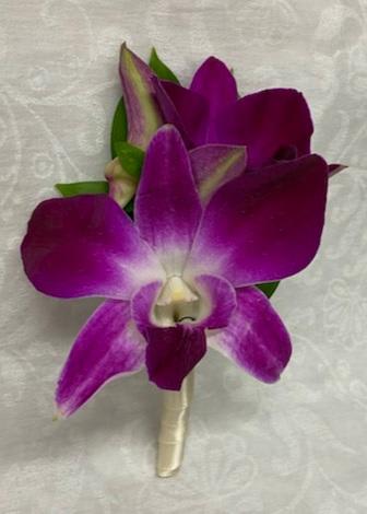 Purple orchid boutonniere with green accents on a wrapped stem