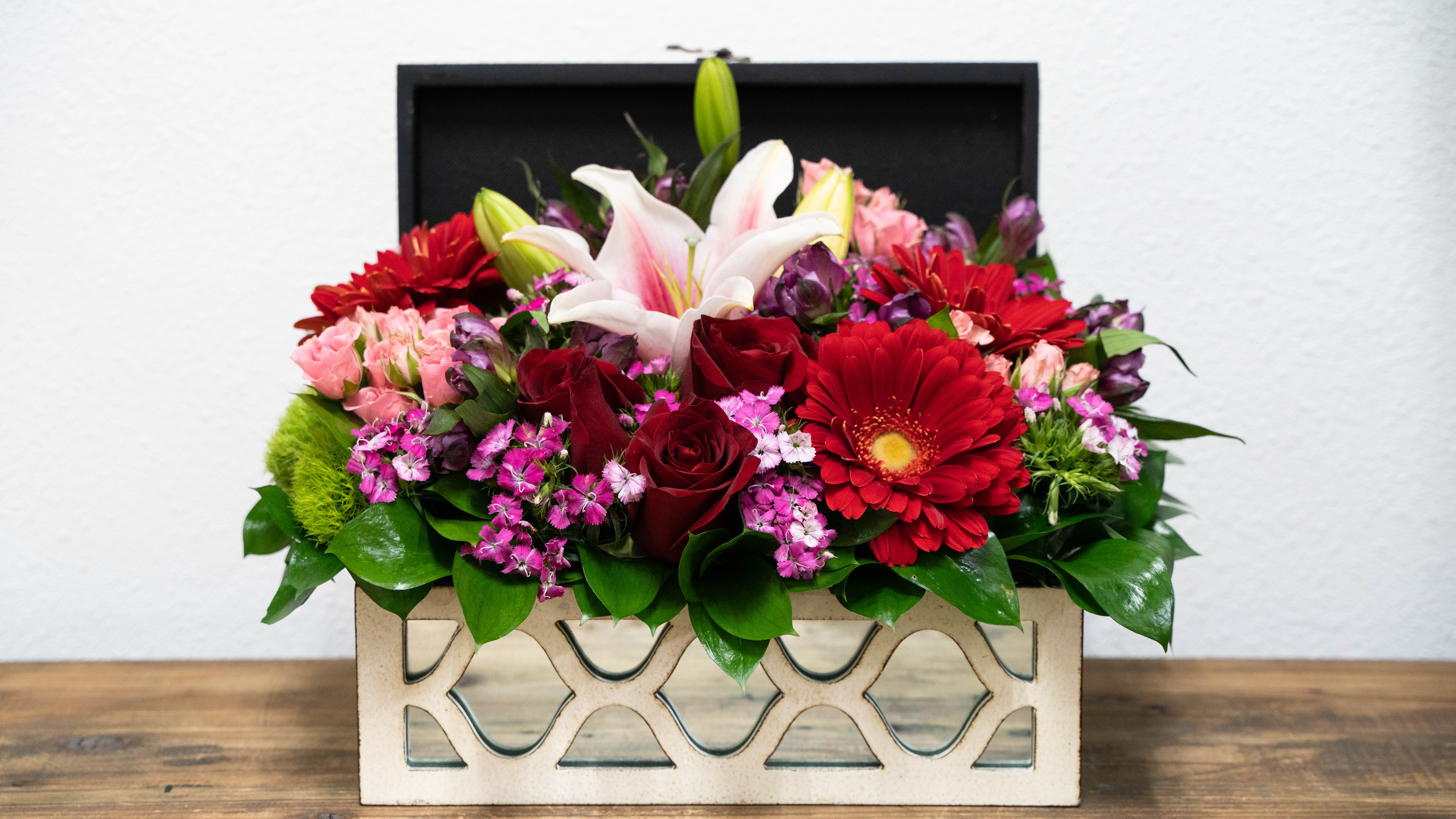 Mixed bouquet in a decorative rectangular box with red, pink, and white blooms