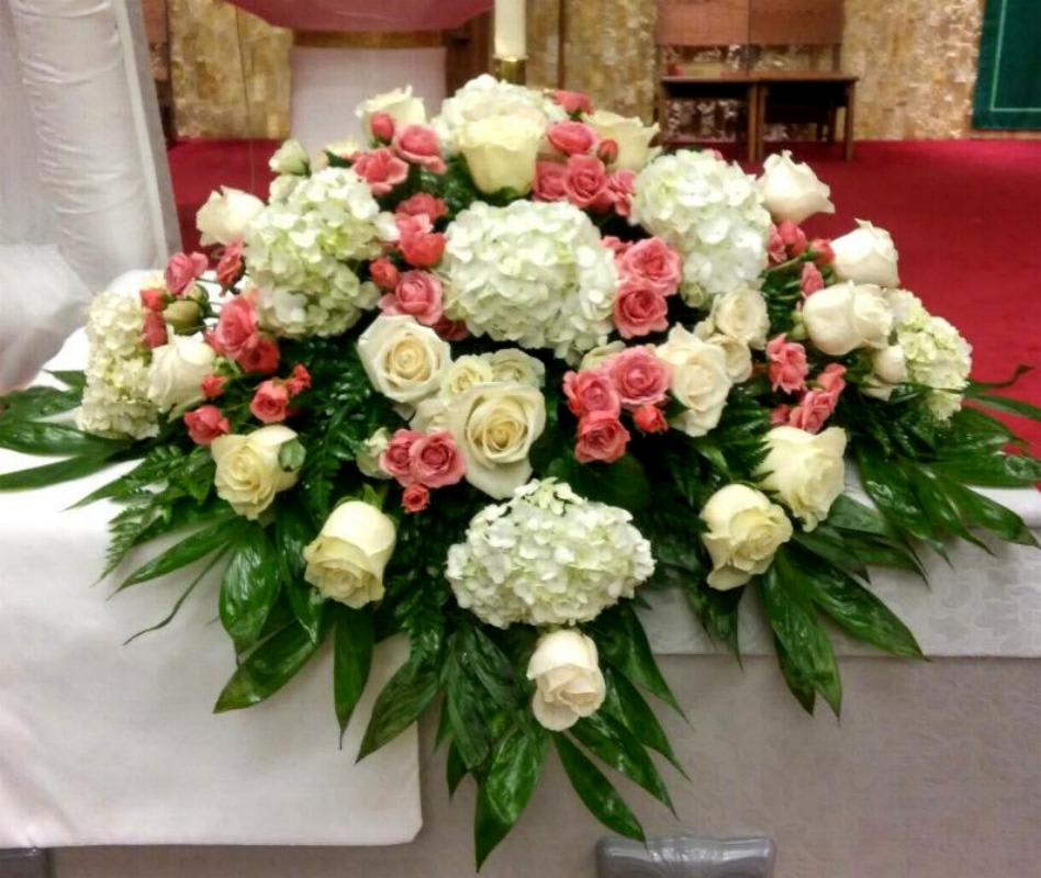 Large white and pink rose arrangement with hydrangeas on a table