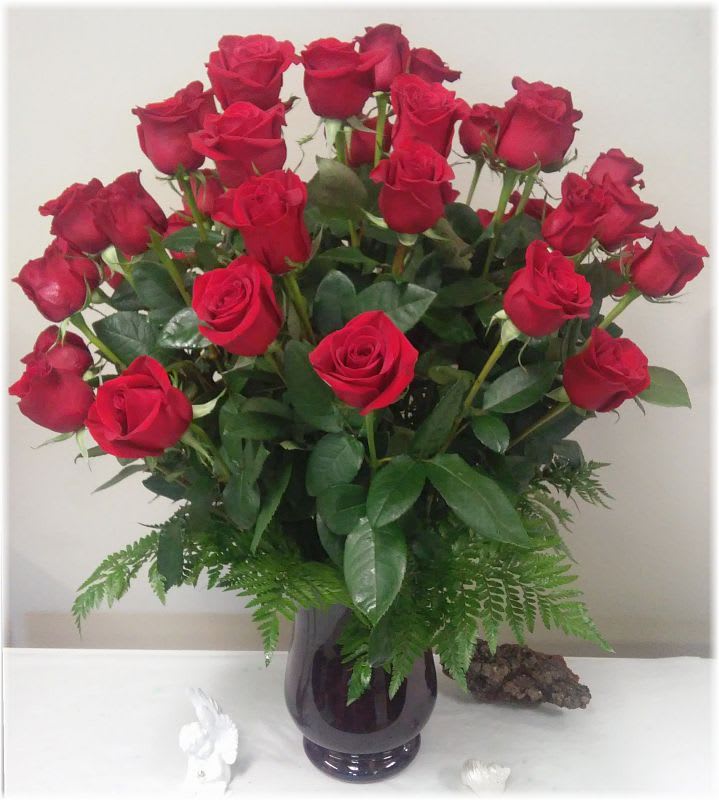 Bouquet of red roses in a dark glass vase